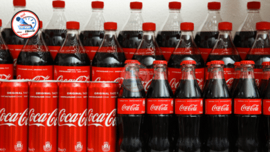 مجموعة متنوعة من المشروبات الغازية الملونة في أكواب مع ثلج وفقاعات، على خلفية حيوية تعكس الانتعاش.